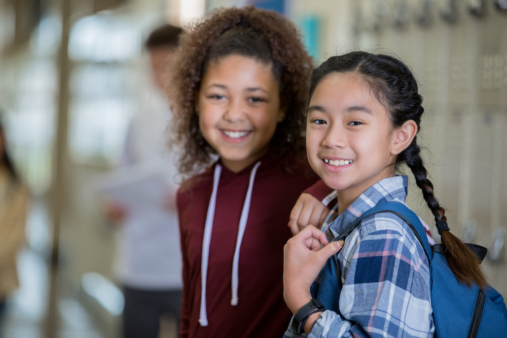 Two school-aged girls smiling.