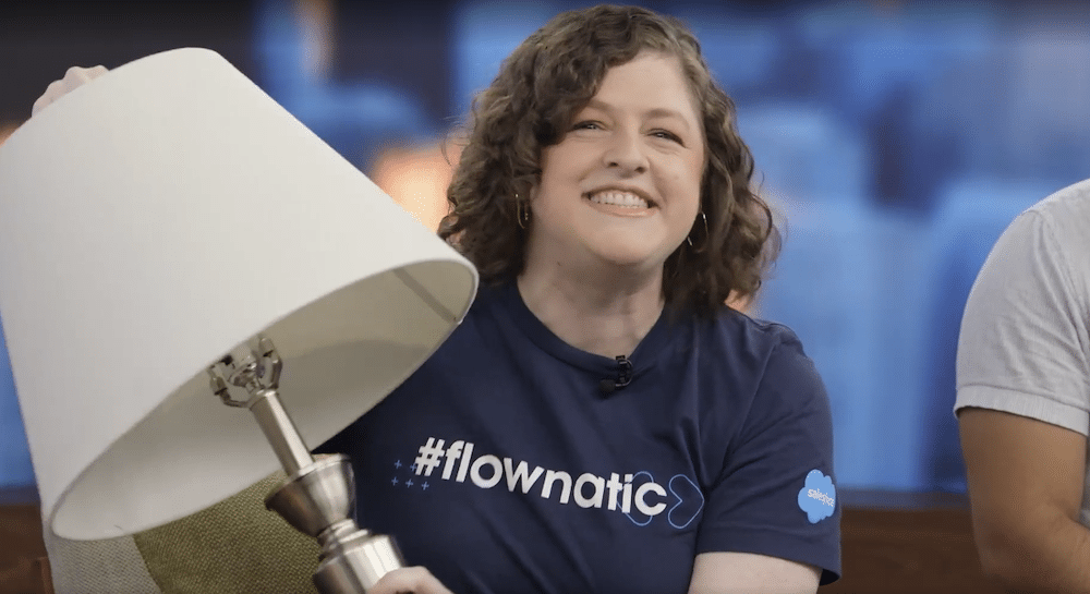 Diana Jaffe wearing a Flownatic shirt and holding up her lamp with a shining smile.